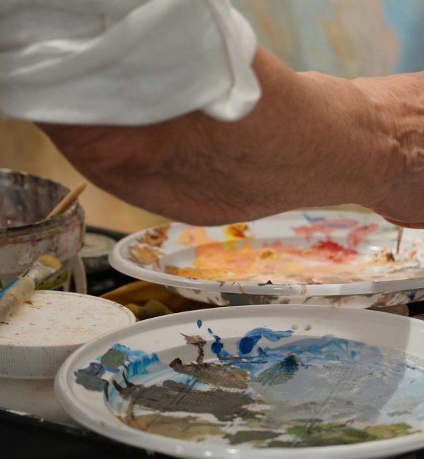 Manos de artista ajustando detalles en un encargo de arte de un retrato.