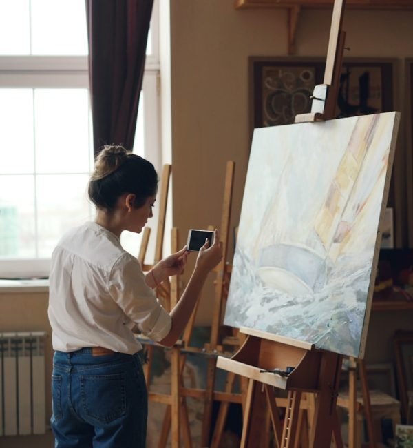 Gemma, artista de Gemmelart, concentrada pintando un lienzo en su estudio.